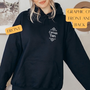 May include: Black hooded sweatshirt with a white graphic that says "Captain Trips" on the front. The graphic is surrounded by a decorative floral design.