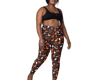 May include: Black leggings with a Halloween print featuring pumpkins, bats, ghosts, cats, and witches' hats. The print is in orange, white, and black.