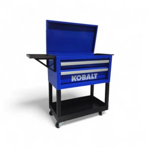 May include: A blue metal rolling tool cart with a hinged lid, two drawers with silver handles, and a side shelf. The front of the bottom drawer features the white text KOBALT. The cart is supported by a black frame with four caster wheels.