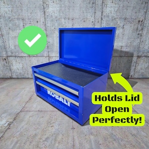 May include: A bright blue metal toolbox with two drawers and a hinged lid. The toolbox has silver drawer pulls and the brand name "KOBALT" is visible on the front. The lid is open, revealing a dark interior.