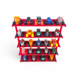 May include: A red five-tiered display stand holding twenty miniature monster truck toys. Each truck features oversized black tires and unique colorful designs, including various animal-themed bodies, arranged in rows on the tiered shelves.