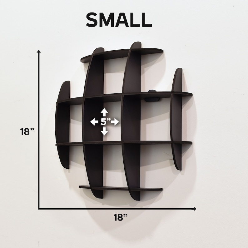 May include: A small, black, globe-shaped wall shelf with 12 compartments. The shelf is 18 inches in diameter and each compartment is 5 inches wide. The shelf is mounted on a white wall.