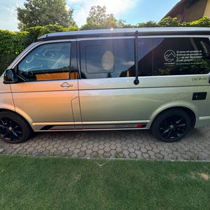 Pode incluir: Uma carrinha prateada com guarnições pretas e um suporte de tejadilho preto. A carrinha tem um autocolante na janela traseira que diz "www.call-gadgets.de" e "Call Gadgets - Ihr EDC Shop seit 2017". A carrinha também tem um autocolante no lado que diz "OCEAN".