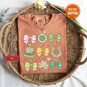 a t - shirt with a bow tie on it sitting on a wicker basket