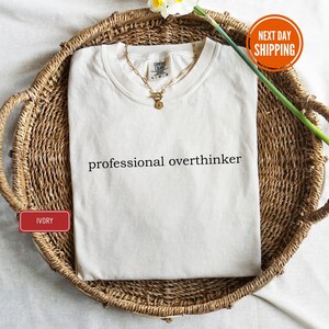 a white shirt that says professional overthiker on it