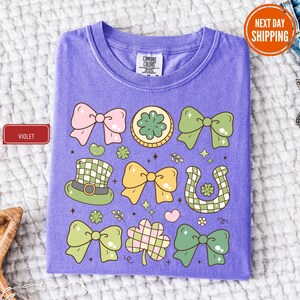 a purple t - shirt with green and pink bows on it