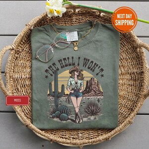 a t - shirt with a picture of a woman wearing a cowboy hat and glasses