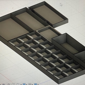 May include: A gray, multi-compartment organizer with various sections and trays. The design includes a grid of small square compartments, larger rectangular spaces, and open trays, all in a geometric layout.