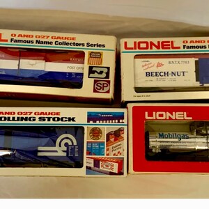 May include: Four boxes of Lionel O and 027 gauge model train rolling stock. The boxes feature red, white, and blue colour schemes with various company logos and names, including Conrail, Beech-Nut, and Mobiligas.