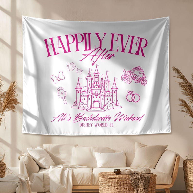 Op de afbeelding: Witte stoffen banner met roze tekst die "Happily Ever After" luidt, met een roze kasteel, koets en andere Disney-thema illustraties. De tekst onder het kasteel luidt "Ali's Bachelorette Weekend, Disney World, FL."
