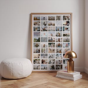 Op de afbeelding: Een grote fotocollage met een lichte houten lijst. De collage bevat talrijke kleine foto's. Een witte poef en een gouden lamp op een stapel boeken staan op de voorgrond. De vloer is van hout.