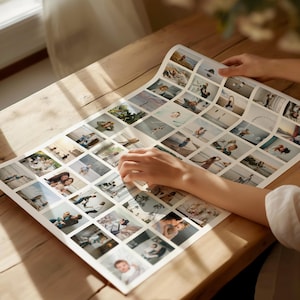 Op de afbeelding: Een grote, rechthoekige fotocollage-afdruk met talrijke kleine vierkante afbeeldingen. De afdruk ligt op een houten oppervlak, met gedeeltelijk zichtbare handen die de afdruk vasthouden en aanpassen. De afbeeldingen in de collage lijken familiefoto's te zijn.
