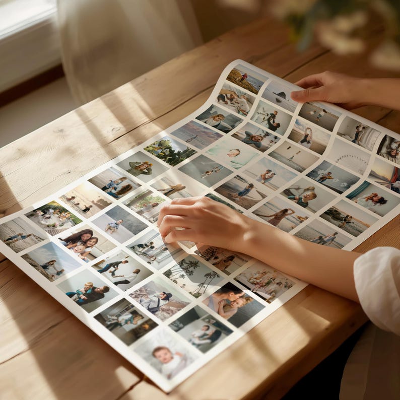 Op de afbeelding: Een grote, rechthoekige fotocollage-afdruk met talrijke kleine vierkante afbeeldingen. De afdruk ligt op een houten oppervlak, met gedeeltelijk zichtbare handen die de afdruk vasthouden en aanpassen. De afbeeldingen in de collage lijken familiefoto's te zijn.