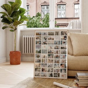 Op de afbeelding: Een ingelijste fotocollage met veel kleine vierkante foto's. De foto's tonen familiesc&egrave;nes. De lijst is lichtbruin en de collage leunt tegen een muur bij een raam.