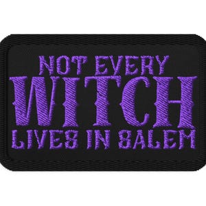 May include: Black rectangular patch with purple embroidered text that reads "NOT EVERY WITCH LIVES IN SALEM". The patch has a black border and is likely for clothing or accessories.
