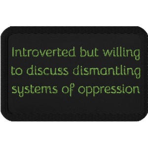 May include: Black rectangular patch with green embroidered text that reads: "Introverted but willing to discuss dismantling systems of oppression."
