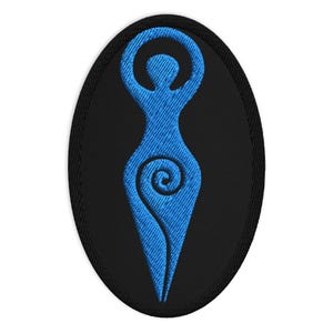 May include: Oval-shaped embroidered patch featuring a blue stylized female figure on a black background. The figure has arms raised above the head and a spiral design at the lower torso. The patch is likely for clothing or accessories.