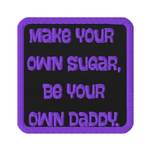 May include: Embroidered patch with a black background and a purple border. The patch features the text "Make Your Own Sugar, Be Your Own Daddy" in purple thread.