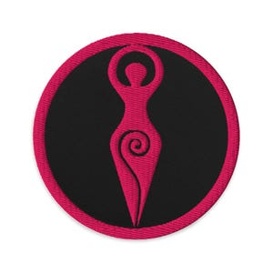 May include: Embroidered patch featuring a stylized pink female figure within a black circle, framed by a pink border. The figure has arms raised and a spiral design. Ideal for jackets, bags, or other fabric items.