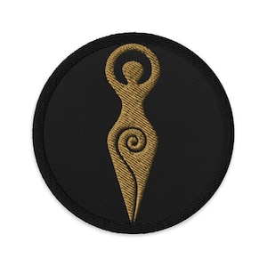 May include: Embroidered patch featuring a gold-colored stylized female figure with arms raised, set against a black circular background. The figure has a spiral design on the lower half. The patch has a black border.