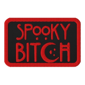 May include: Embroidered patch with the words "SPOOKY BITCH" in red, stylized lettering on a black background. The patch has a red border and is rectangular in shape. Perfect for Halloween or spooky season.
