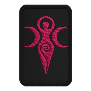 May include: Embroidered patch featuring a magenta Triple Goddess symbol on a black rectangular background. The symbol depicts a central female figure with arms raised, flanked by crescent moons. The design includes a spiral at the figure's center.