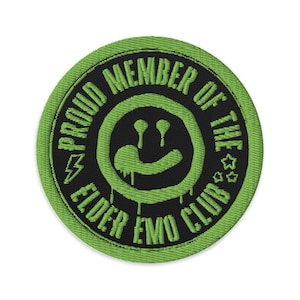 May include: Round, embroidered patch with a black center and a green border. The text "PROUD MEMBER OF THE ELDER EMO CLUB" encircles a dripping smiley face. A lightning bolt and stars are also included in the design.
