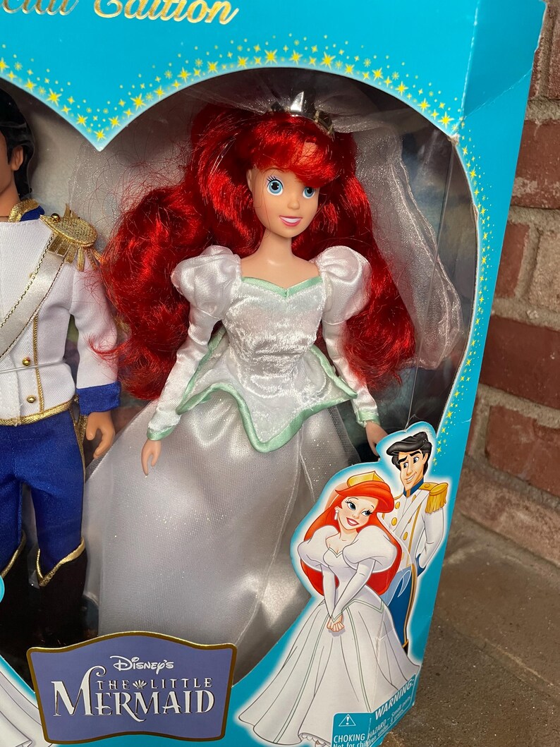 May include: Ariel doll from Disney's The Little Mermaid, in a white wedding dress with a mint green trim. The doll has red hair and is in a box with Prince Eric. The box is blue with gold stars and the words "Limited Edition".