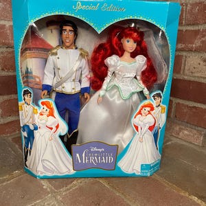 May include: A Special Edition Disney's The Little Mermaid doll set in a teal box. The box features a heart-shaped window showcasing Ariel in a white wedding dress and Prince Eric in a white uniform. The box has the words "Special Edition" on top.