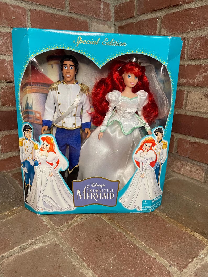 May include: A Special Edition Disney's The Little Mermaid doll set in a teal box. The box features a heart-shaped window showcasing Ariel in a white wedding dress and Prince Eric in a white uniform. The box has the words "Special Edition" on top.