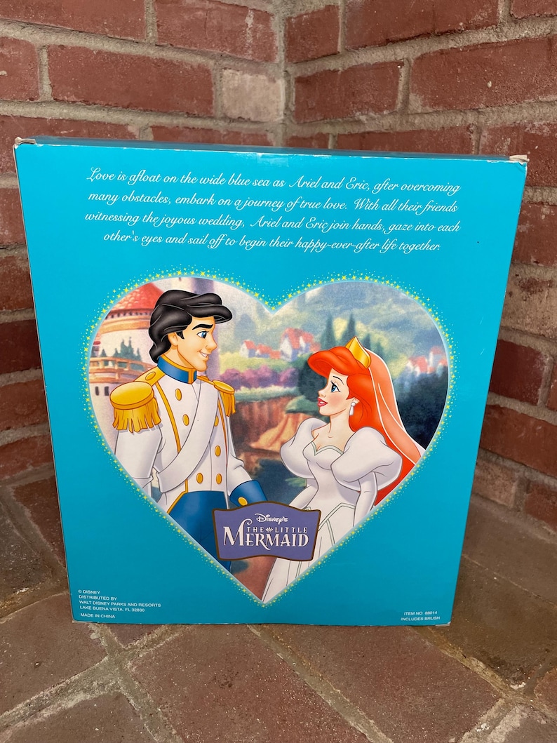 May include: A teal box featuring Disney's The Little Mermaid. The box art depicts Ariel and Eric in a heart-shaped frame, with text describing their love story. The box has text that reads "Love is afloat on the wide blue sea..."