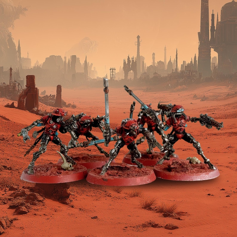 May include: Miniature figurines of robotic soldiers in red and black armor, posed on red circular bases. The figures are set against a desert landscape with a city in the background. The scene evokes a science fiction or fantasy theme.