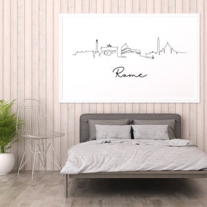 May include: A black and white line drawing of the Rome skyline with the word "Rome" written below. The drawing is framed and hanging on a white wood wall above a gray bed with white bedding.