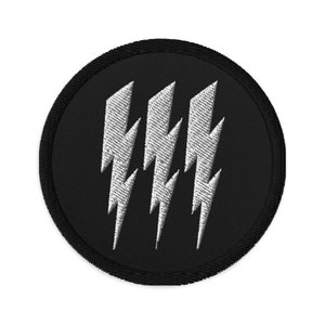 Peut inclure: Un patch brodé noir avec quatre éclairs blancs dans un cercle.