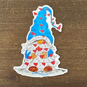 May include: A blue gnome with a white beard is wrapped in a string of red hearts. The gnome is wearing a blue hat with red hearts on it. The gnome is standing on a white background. The text "RedTeslanArt" is written at the bottom of the image.