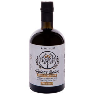 K&ouml;nnte beinhalten: Eine dunkle Glasflasche mit Manaki Olive Village Batch nativem Oliven&ouml;l extra und schwarzem Verschluss. Das wei&szlig;e Etikett zeigt eine kreisf&ouml;rmige Baumillustration, den Text Village Batch, Single Farm Origin und das Wort Delicate.