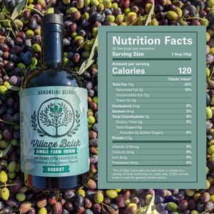 May include: A dark glass bottle of Village Batch single farm origin raw organic extra virgin olive oil with a label featuring a tree illustration and a nutrition facts panel listing 120 calories per 15g serving size, set against a background of olives.