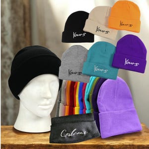 May include: A collection of beanies in various colors, including black, beige, orange, teal, gray, and purple. Each beanie has the word "Yours" embroidered on the front. A black headband with the word "Corlcone" is also visible.