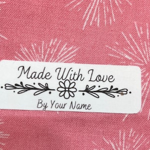 May include: White rectangular label with black text that reads "Made With Love By Your Name". The label has a simple floral design with a flower and leaves.
