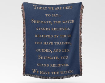 May include: A navy blue woven throw blanket with the text "TODAY WE ARE HERE TO SAY... SHIPMATE, THE WATCH STANDS RELIEVED. RELIEVED BY THOSE YOU HAVE TRAINED, GUIDED, AND LED. SHIPMATE, YOU STAND RELIEVED. WE HAVE THE WATCH."