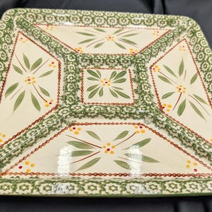 Puede incluir: Un plato de servir cuadrado de cerámica con un diseño floral verde y blanco. El plato tiene cuatro secciones y un borde verde.