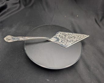 Servidor de pasteles antiguo chapado en plata, elegantemente grabado.