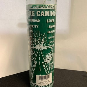 May include: A green Abre Camino candle in a clear glass jar. The candle has white text that includes the words "Prosperity", "Love", and "Health". The candle also has a graphic of a road leading to success.