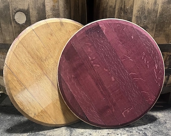 May include: Two round wooden barrel head tabletops. One is natural wood and the other is stained a deep purple.