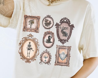 May include: Ivory-colored t-shirt featuring a collection of framed vintage-style illustrations. The illustrations include a skeleton, a ghost, a rabbit with antlers, and other spooky images. The word "IVORY" is printed at the bottom.