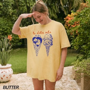 May include: A yellow t-shirt featuring a graphic of two ice cream cones and the text "la dolce vita" in blue and orange.