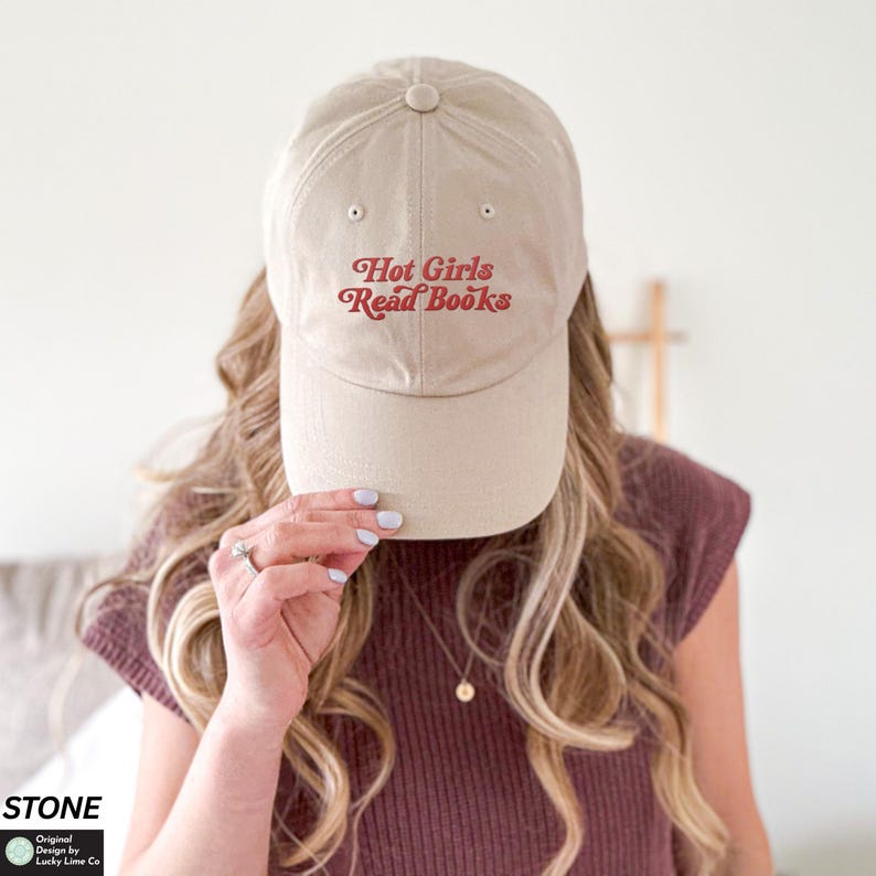 Op de afbeelding: Beige baseballpet met de tekst "Hot Girls Read Books" in rode letters. De pet is gemaakt van zacht materiaal en heeft een gebogen klep. Een casual accessoire.