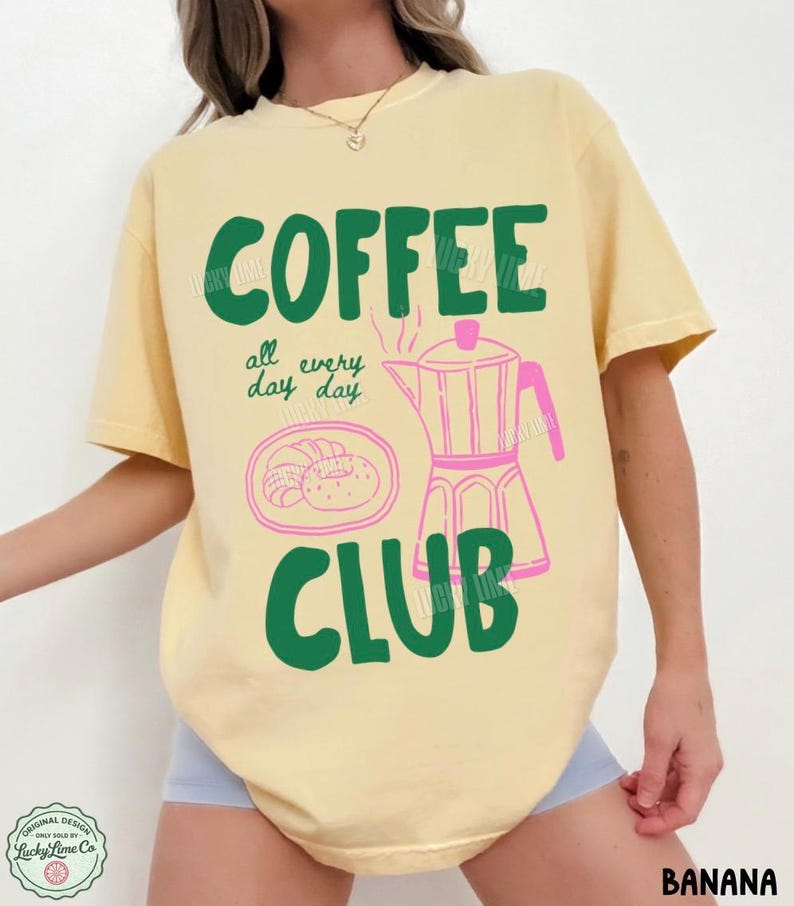 Peut inclure: Un t-shirt jaune p&acirc;le &agrave; manches courtes avec le texte vert COFFEE CLUB, le texte manuscrit vert all every day day, et une illustration au trait rose repr&eacute;sentant une cafeti&egrave;re italienne et une assiette avec un croissant.