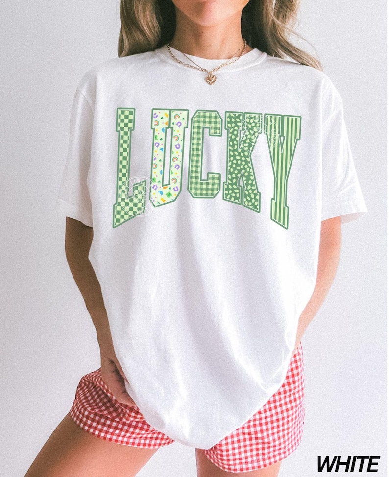 May include: White t-shirt with the word "LUCKY" in green, featuring various patterns like checkered, floral, and striped designs. The shirt is paired with red and white checkered shorts. The word "WHITE" is printed at the bottom.