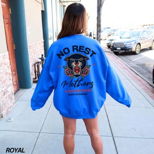 May include: A royal blue sweatshirt with a black panther graphic and the text "No Rest Mothers Born To Endure".